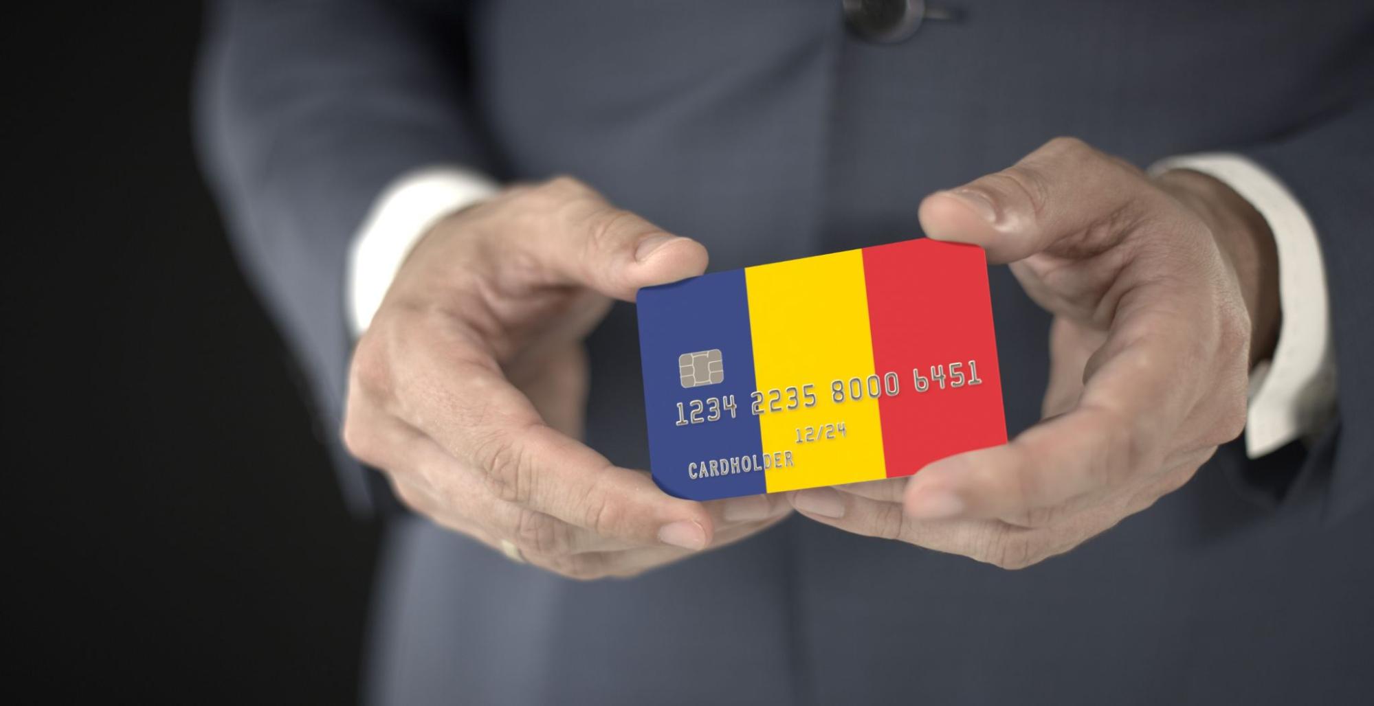 Businessman takes plastic bank card with printed flag of Romania, fictional numbers