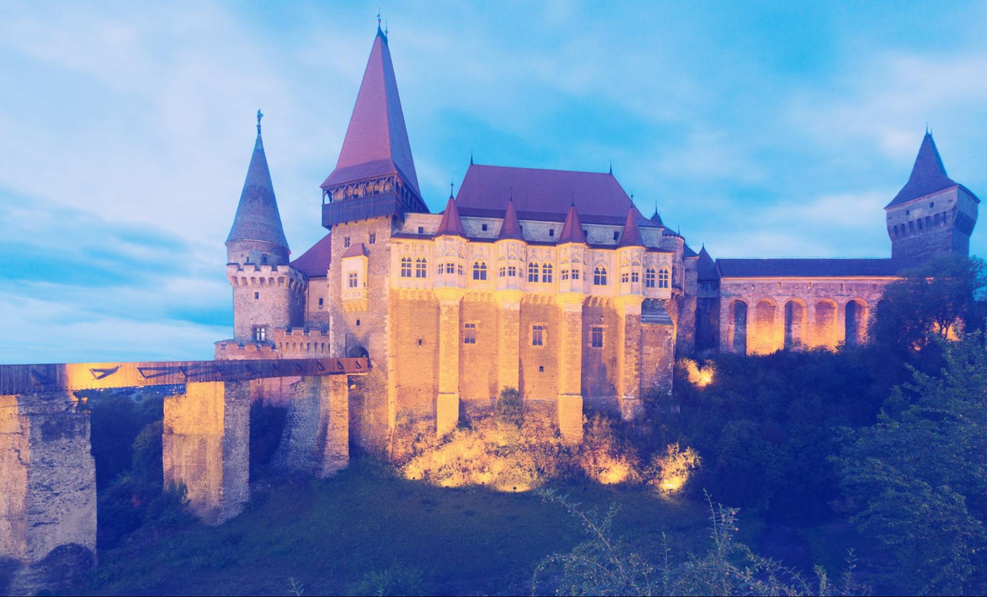 Corvin Castle is on the green mountain in night of Romania