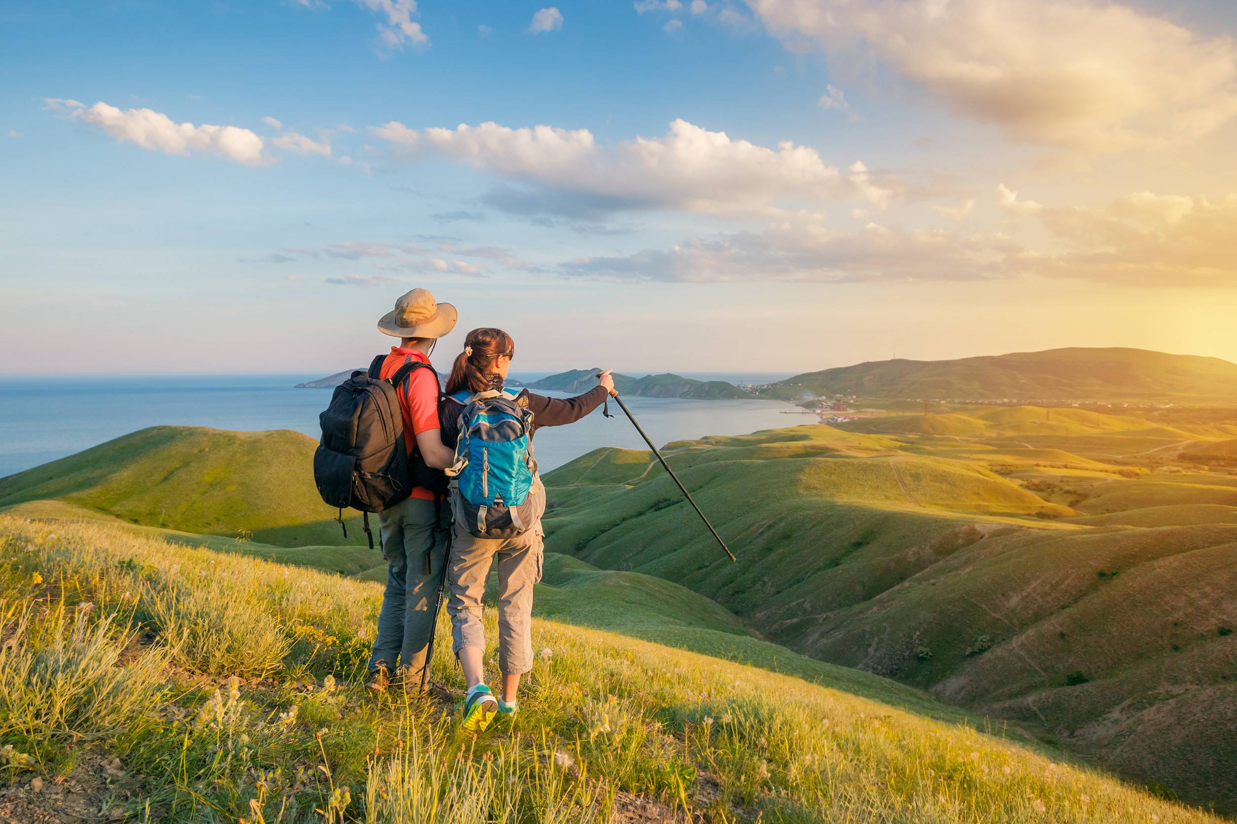 Hiking Couple Hikers With Backpacks Standing On Mountain And Enjoying Sunrise