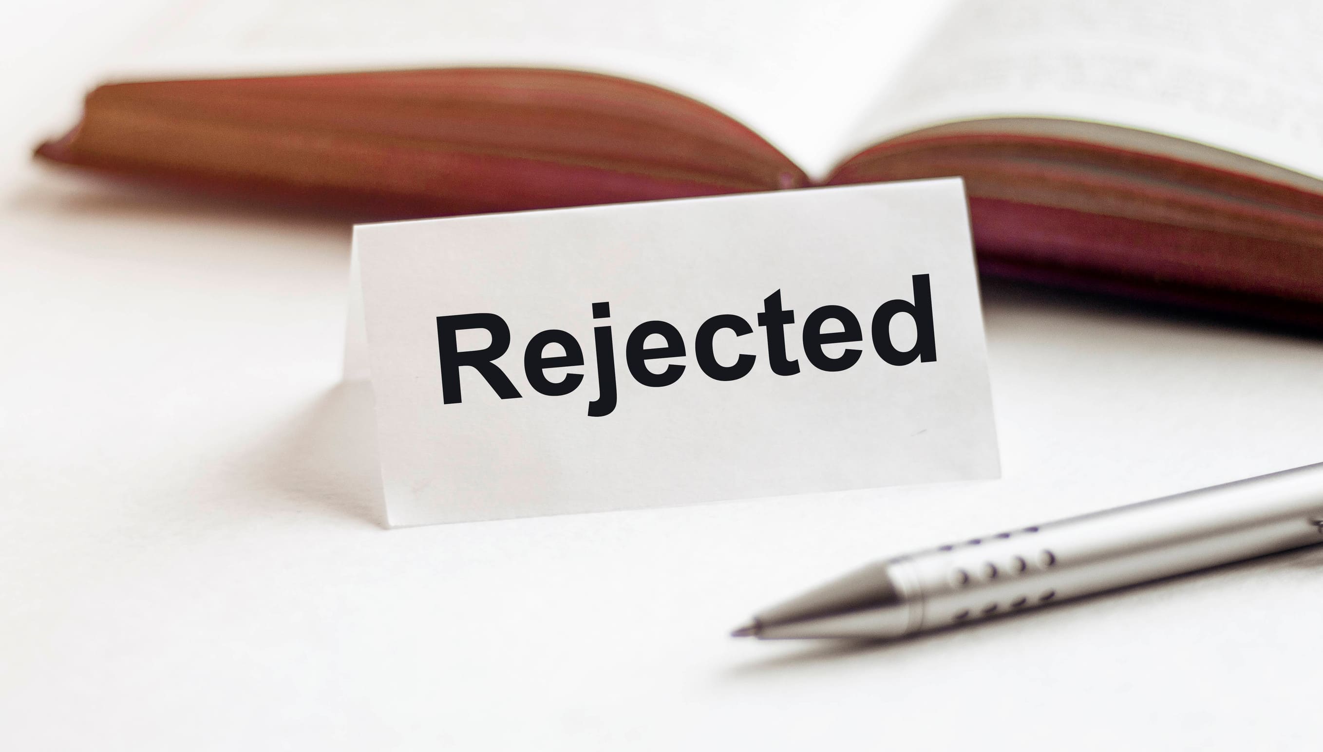 Rejected On The Background Of Books Pens