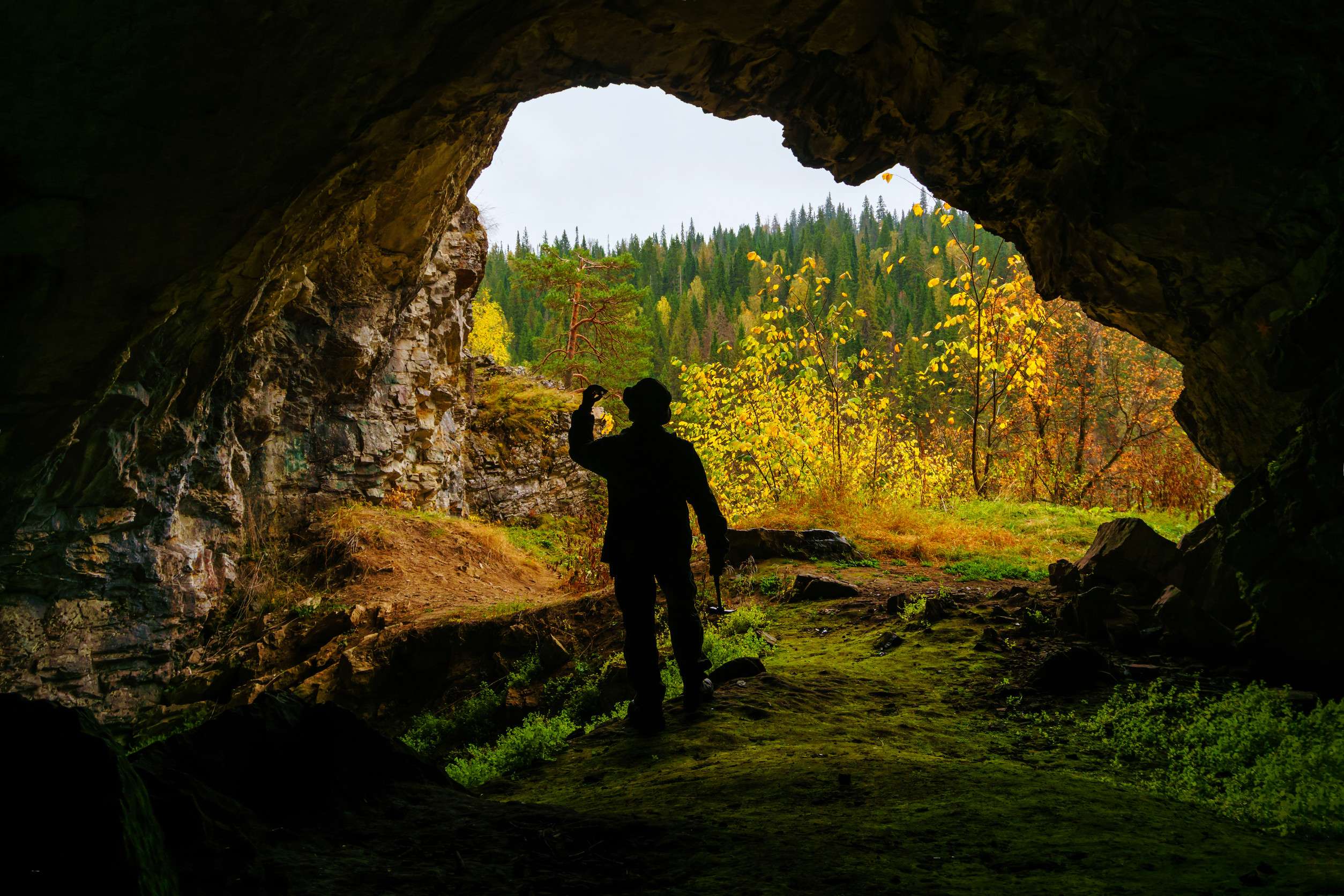 Silhouette Of A Geologist Examining A Mineral Sample Found In A Cave On The Background Silhouette Of A Geologist Examining A Mineral Sample Found In A Cave On The Background