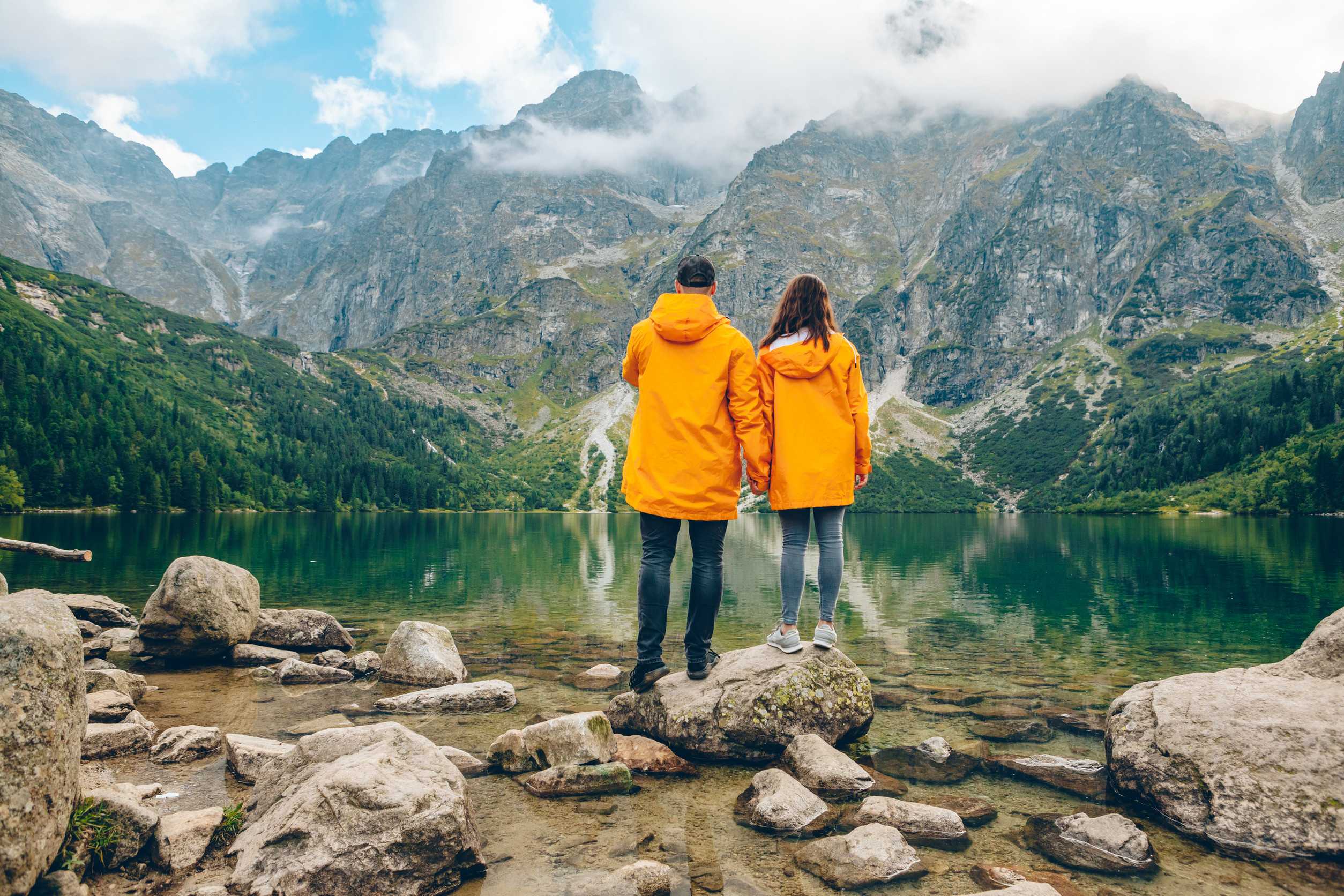 Yellow Raincoat At Sunny Autumn Day Looking At Lake In Tatra Mountains