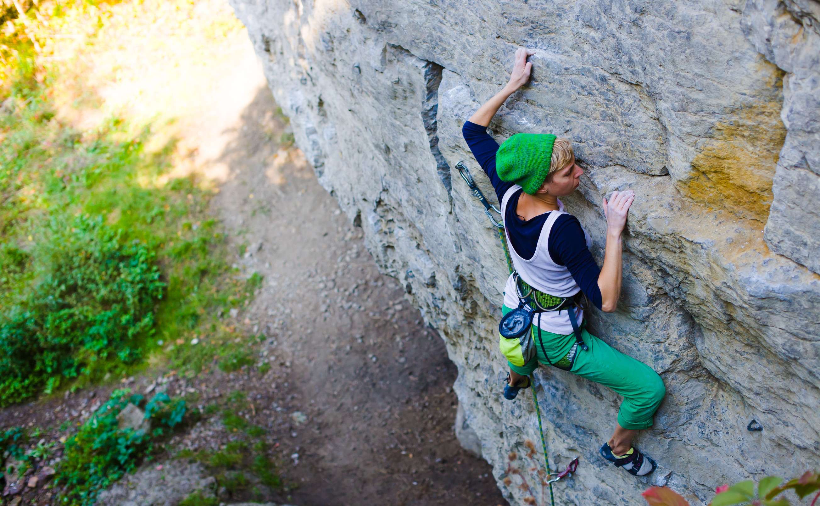 Young Woman With A Rope Engaged In The Sports Of Rock Climbing On The Rock Young Woman With A Rope Engaged In The Sports Of Rock Climbing On The Rock
